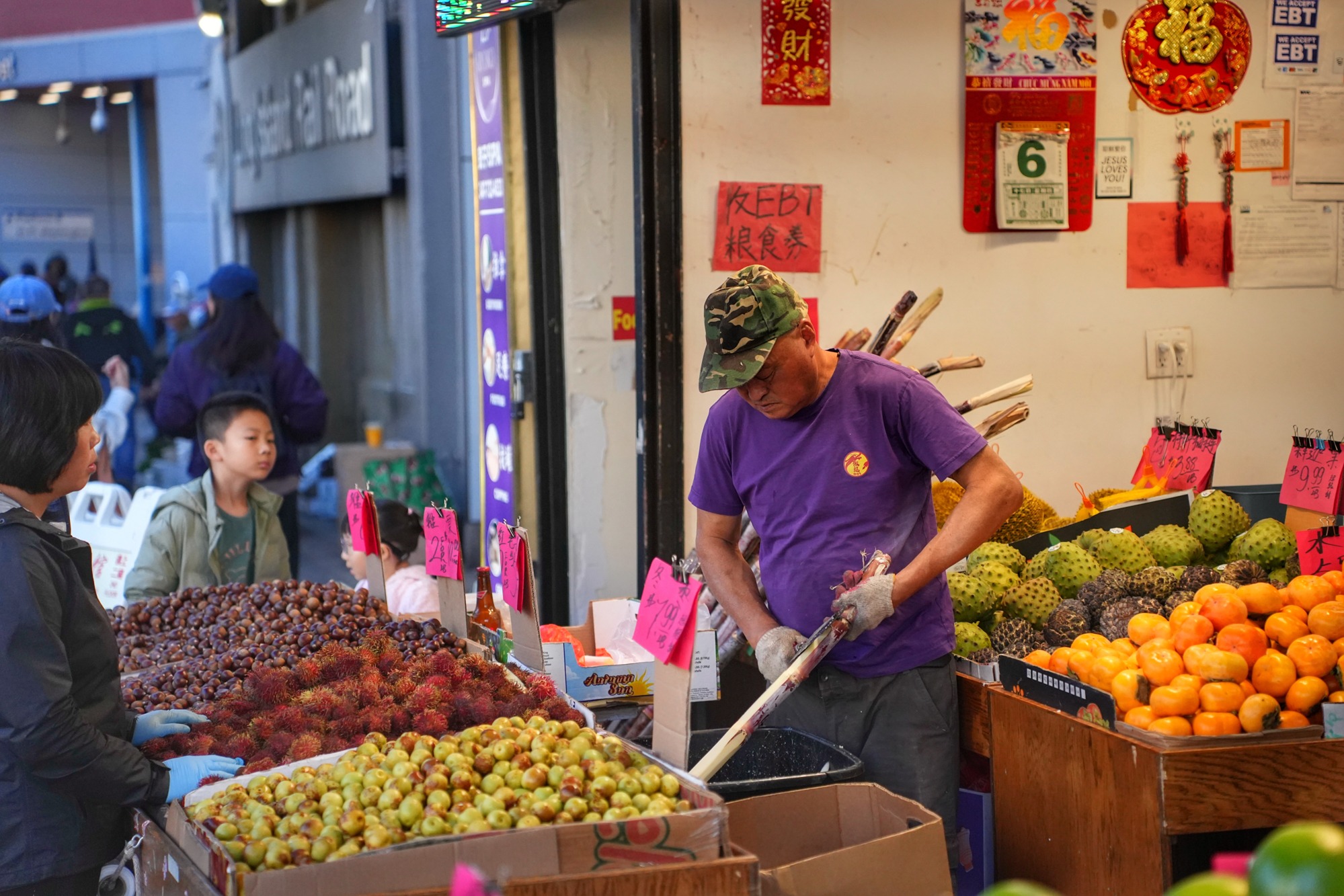 A vendor cuts sugar cane as a child watches. Nov. 8, 2025.