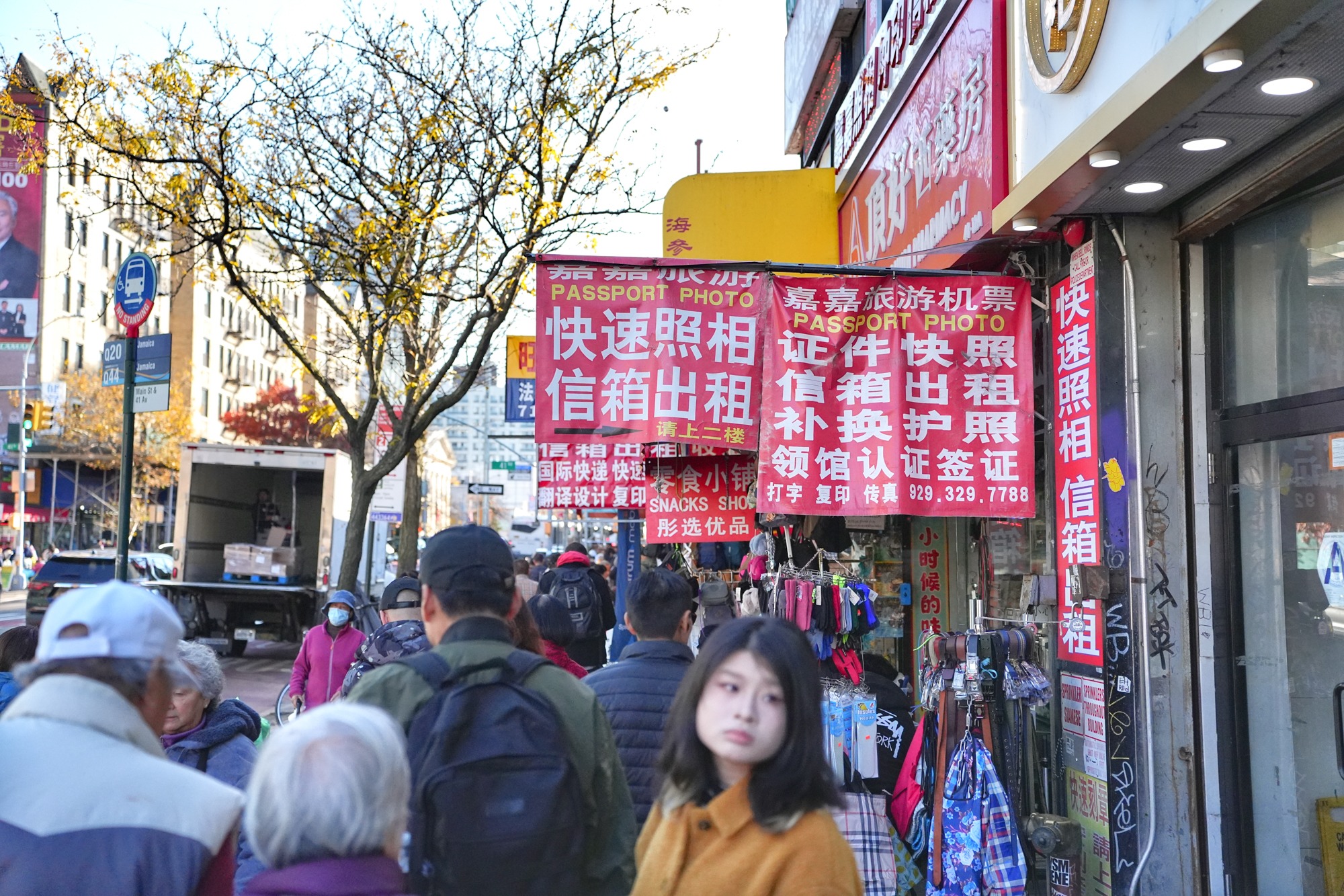 Signs advertise passport photos, document services, and other businesses tied to migration and travel. Nov. 8, 2025.