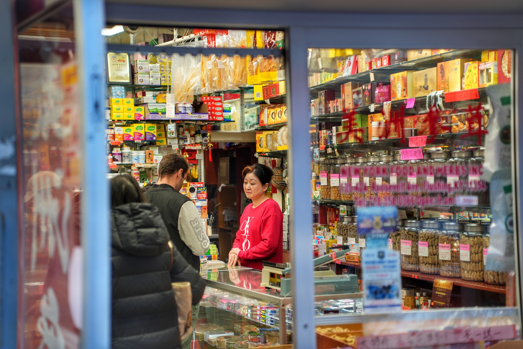 A shopkeeper assists customers inside an herbal-medicine and health-products store. Nov. 8, 2025.