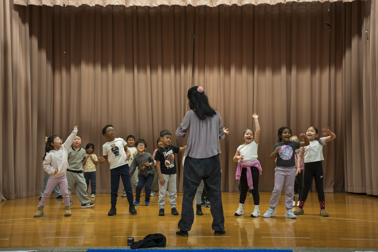 Following Tang’s directions, the children spread across the stage.