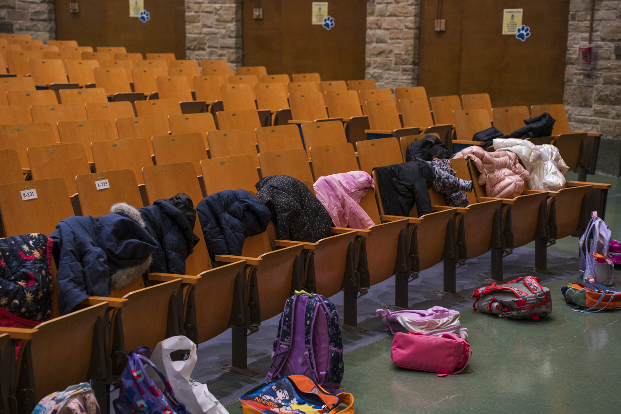 The children leave coats and backpacks in the seats before joining the class.