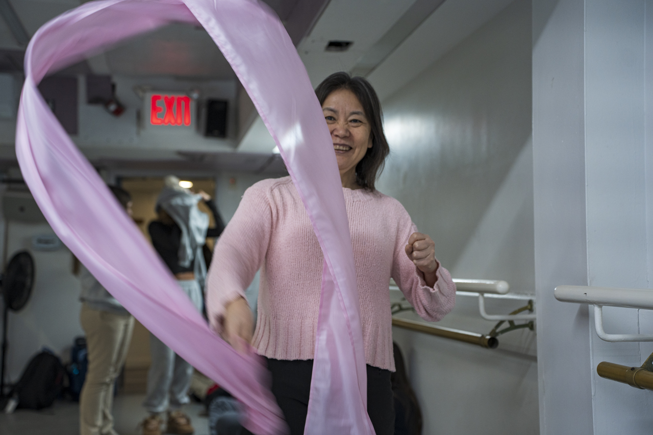Tang demonstrates a movement with a long pink ribbon.
