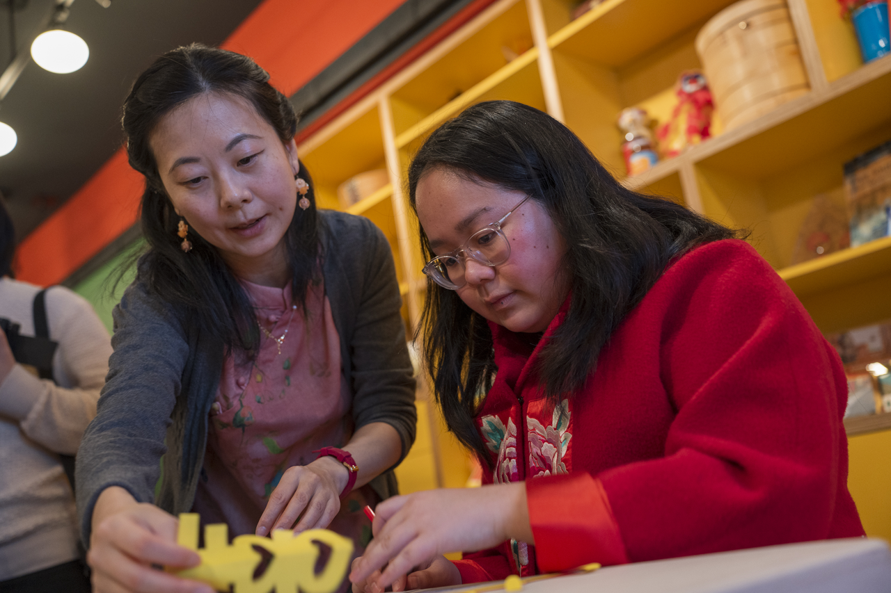 Tang and Think!Chinatown’s Annie Xu work together over the table.