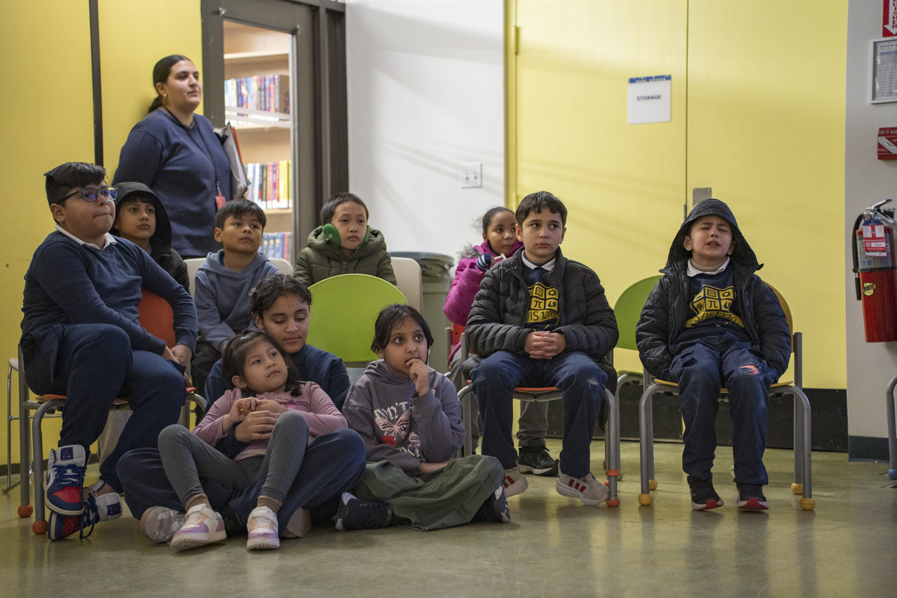 Children watch Tang perform at Queens Public Library, where dance and live music enter a community space.