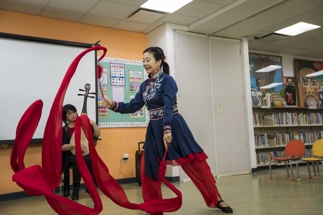 Wearing a Mongolian-style skirt, Tang sends a red ribbon through the air.
