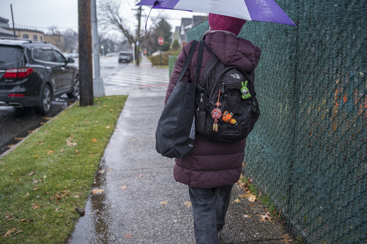 After class, Tang carries her bags through the rain toward her next stop.