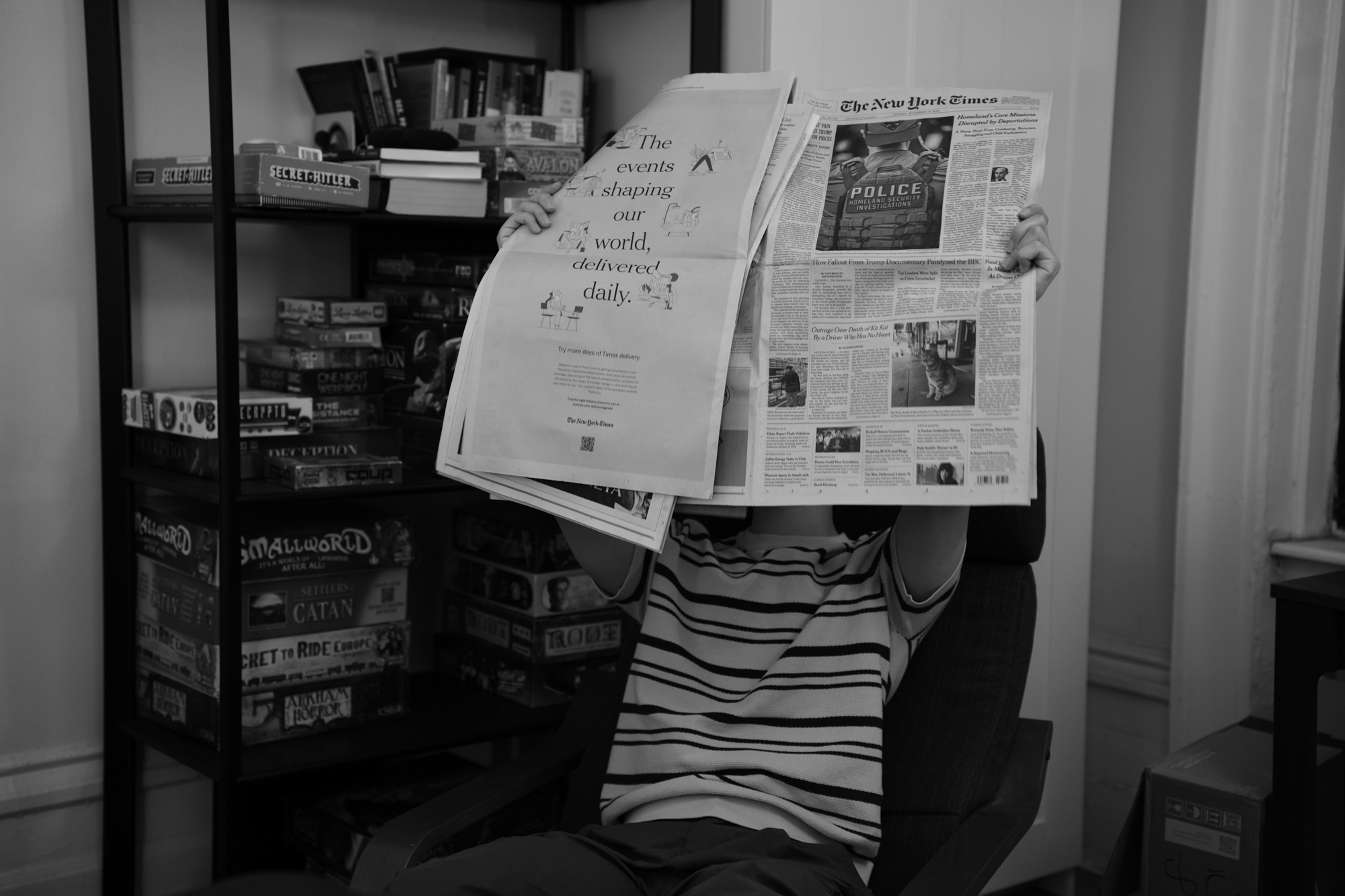 Ziyuan Yin reads The New York Times from a living-room recliner. Nov. 19, 2025.