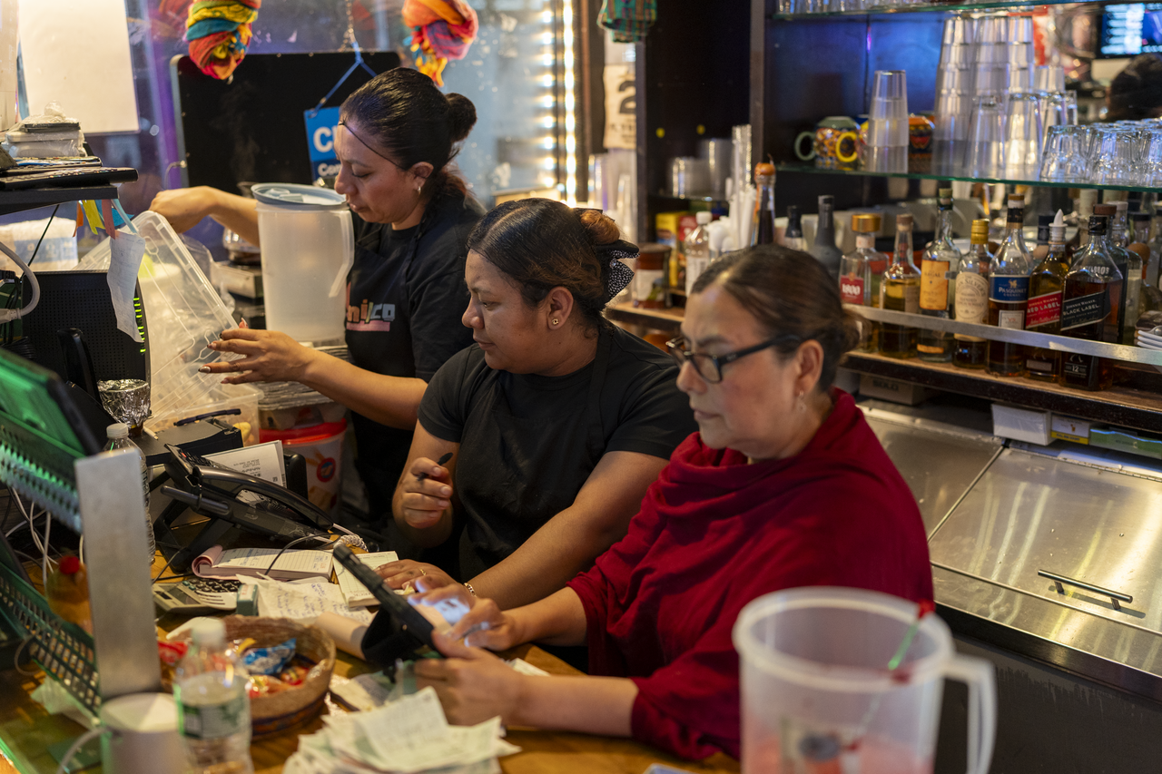 Suzanna works alongside staff behind the counter.