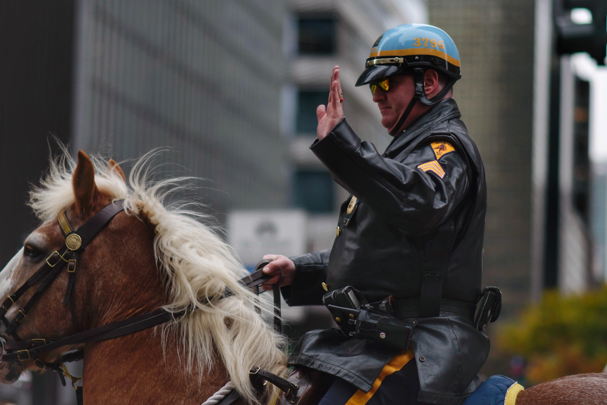 A mounted police officer acknowledges spectators along the route.